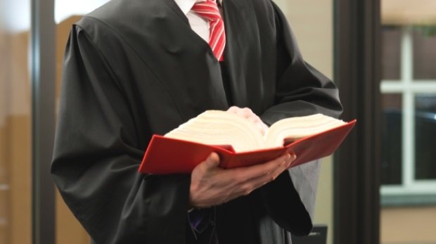 Anwalt mit Gesetzbuch (Symbolbild)