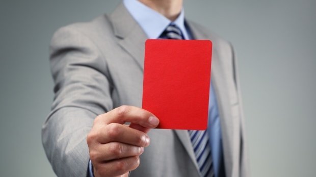 Mann im Anzug zeigt rote Karte