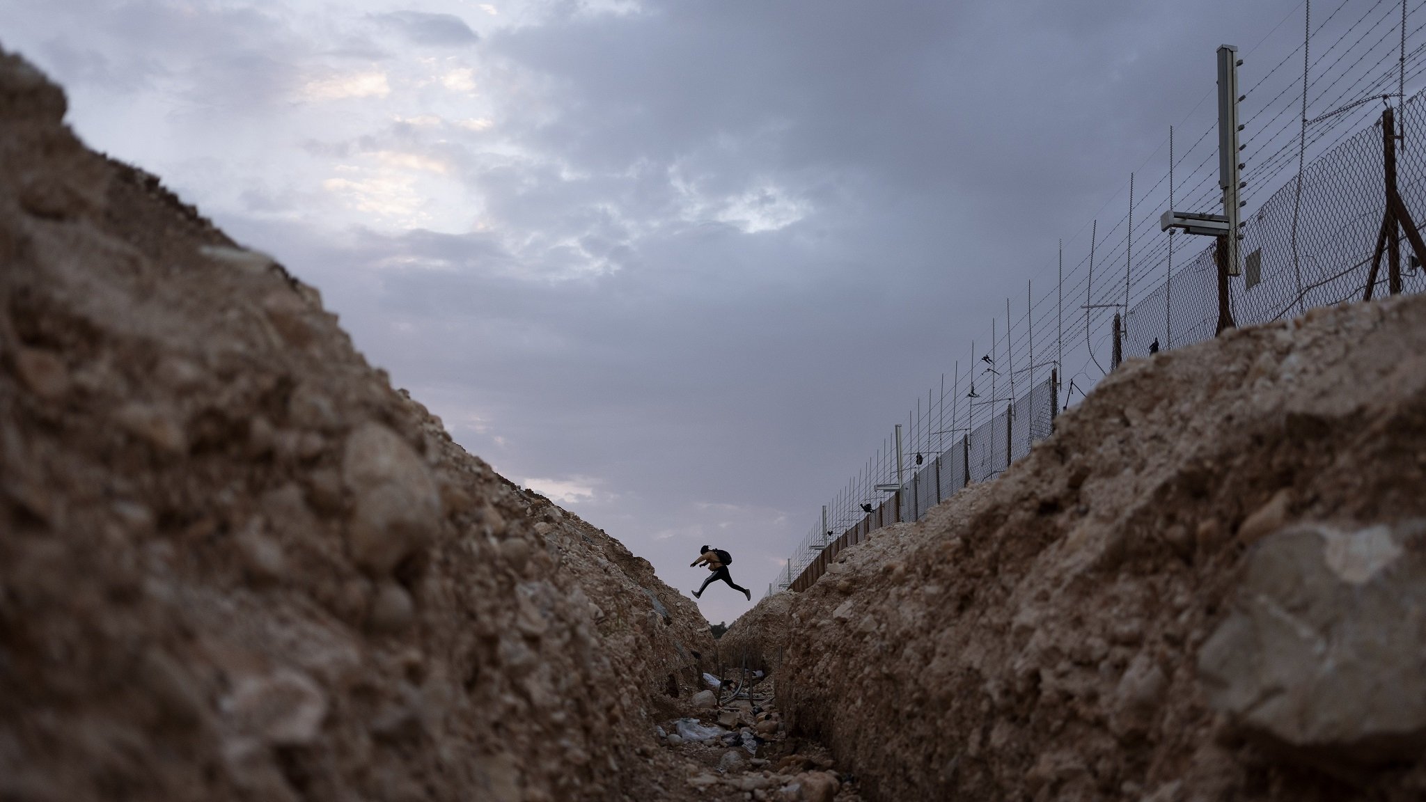 Ein Palästinenser überquert am 6. März 2022 eine Öffnung in der israelischen Trennmauer in der Nähe der Meitar-Kreuzung im Süden des Westjordanlandes nach Israel.