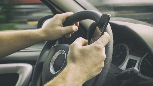 Autofahrer nutzt Smartphone während der Fahrt