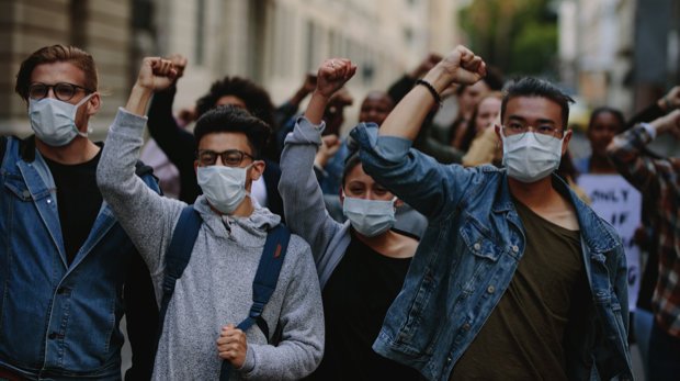 Demonstranten, die einen Mundschutz tragen