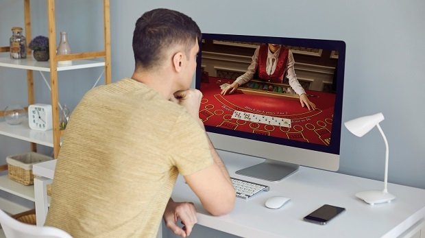 Ein Mann beim Online-Glücksspiel in seinem Arbeitszimmer