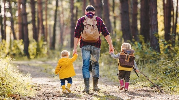 Vater mit Kindern wandernd im Wald (Symbolbild)