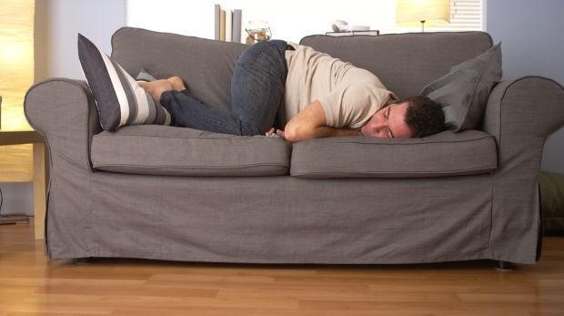 Mann schläft auf der Couch (Symbolbild)