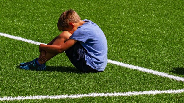 Einsamer Junge auf leerem Fußballplatz (Symbolbild)