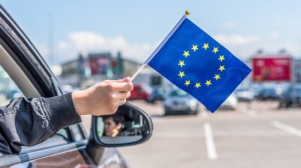 Arm aus Autofenster mit EU-Fahne