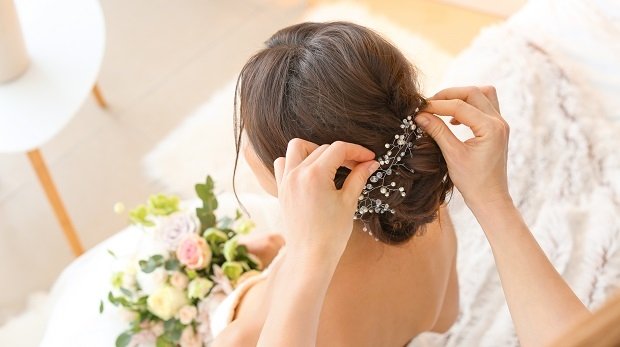 Die Frisur einer Braut wird festgesteckt