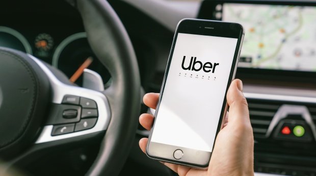 Smartphone mit Uber-App am Steuer