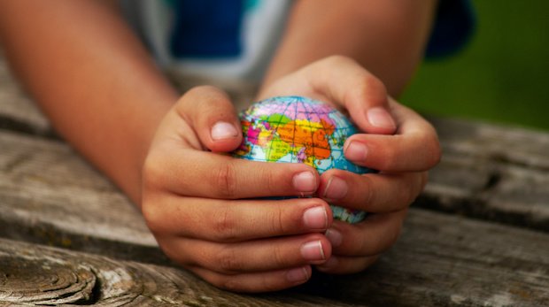 Ein junge hält einen Globus in den Händen