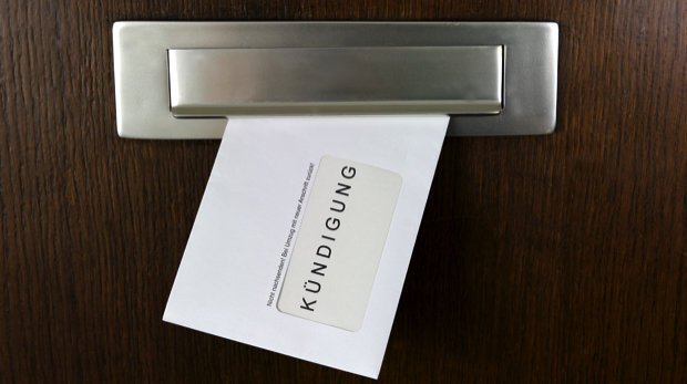 Brief mit der Aufschrift  "Kündigung" hängt im Briefkastenschlitz.