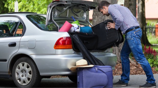 Mann packt sein Auto voll (Symbolbild)