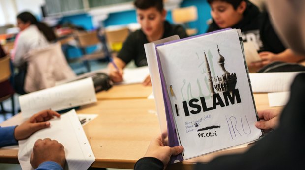 Der Schüler Merdan öffnet seinen seinen selbst gestalteten Ordner beim Islamunterricht in einer siebten Klasse in der Frankfurter Ernst-Reuter-Schule. Das Land Hessen streitet bereits seit Monaten über die Zusammenarbeit mit dem Ditib.