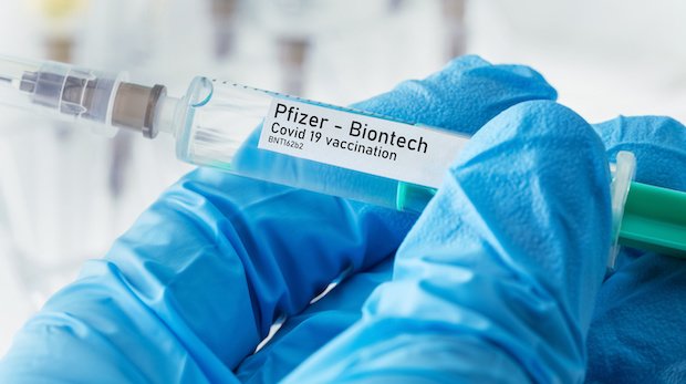 Eine Spritze mit einem Aufkleber "Pfizer - Biontech Covid 19 vaccination"