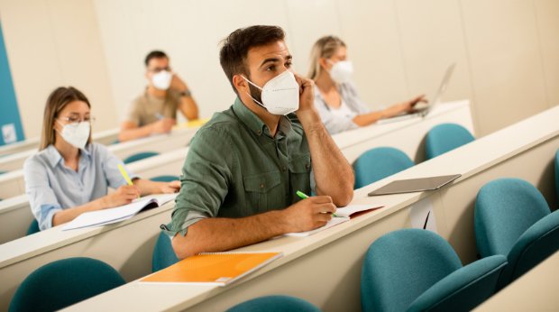 Studierende mit Mund-Nasen-Schutz während einer Vorlesung in einem kleinen Hörsaal (Symbolbild)