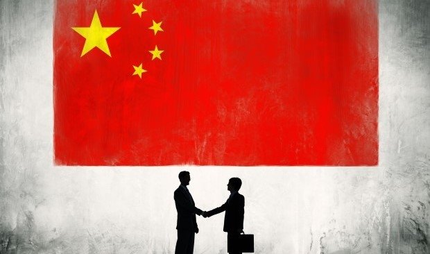 China-Flagge mit zwei Geschäftsleuten, die sich die Hand reichen