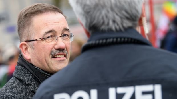 Der Wetzlarer Bürgermeister Manfred Wagner (SPD, l) unterhält sich am Rande einer Demonstration gegen eine geplante NPD-Wahlkampfveranstaltung mit einem Polizeibeamten.