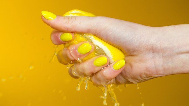 Hand quetscht Zitrone aus