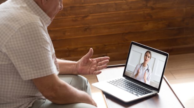 Ein Mann spricht über Videoschaltung mit einer Ärztin