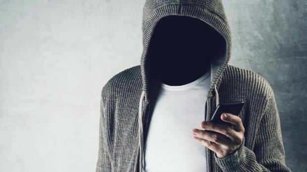 Krimineller mit Smartphone (Symbol)