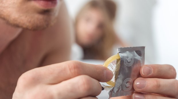 Ein Mann holt ein Kondom hervor (Symbolbild)