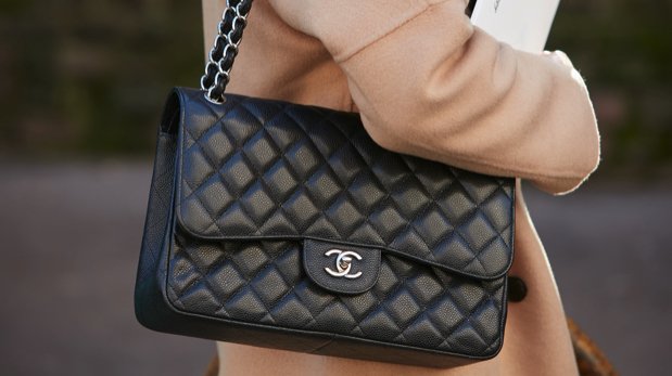 Eine Person mit einer Chanel-Tasche.
