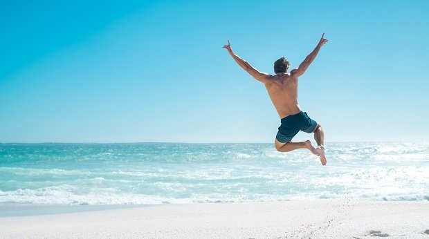 Mann am Strand springt in Luft