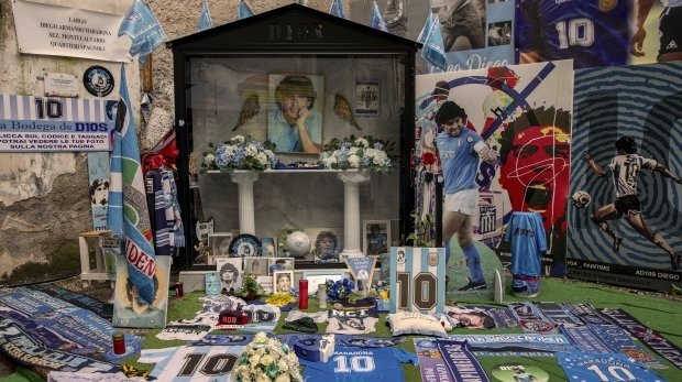 Ein Altar mit Blumen, Bilder, Trikots und Kerzen zu Ehren der Fußballlegende Maradona