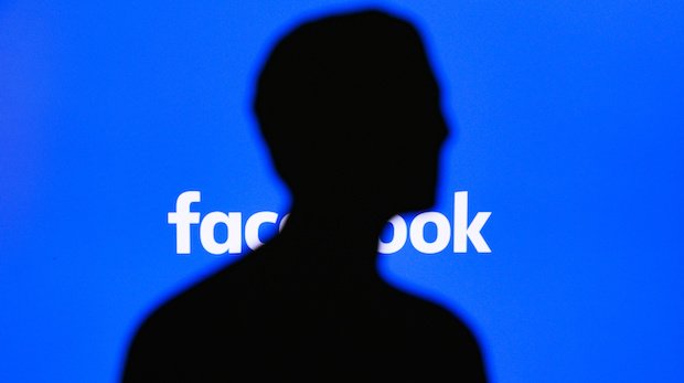 Silhouette von Mark Zuckerberg vor einem Facebook-Logo