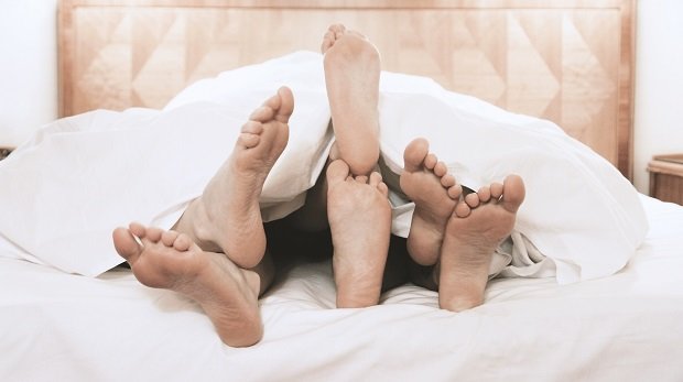 Füße unter einer Bettdecke