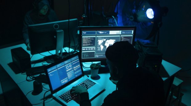 Männern an Rechnern in einem dunklen Raum