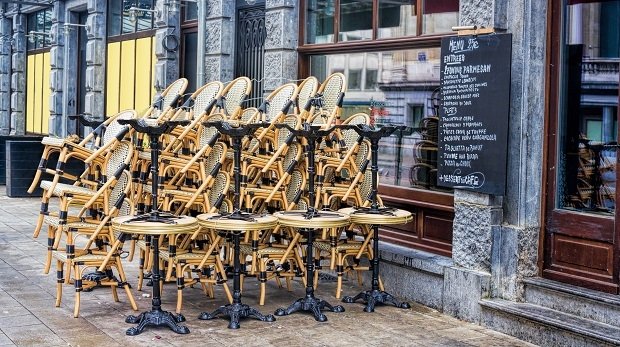 Tische und Stühle gestapelt vor einem Restaurant