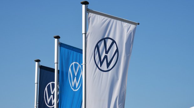 Drei Flaggen mit dem neu gestalteten Logo des Automobilherstellers Volkswagen.