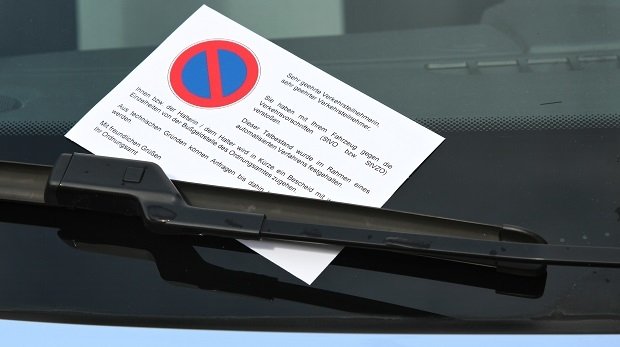 Hinweiszettel auf eine Ordnungswidrigkeit an der Windschutzscheibe eines Autos