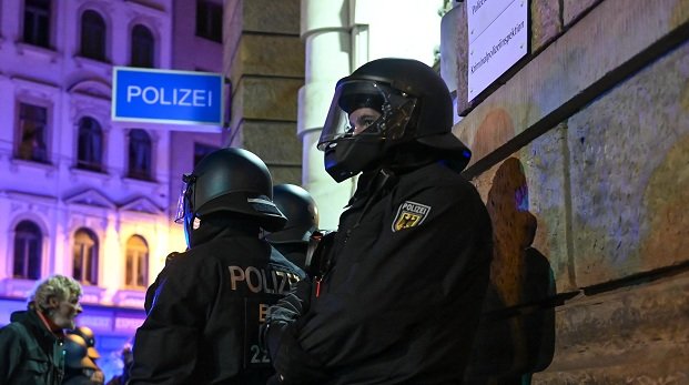 Polizisten schützen eine Dienststelle während der Krawalle in Connewitz