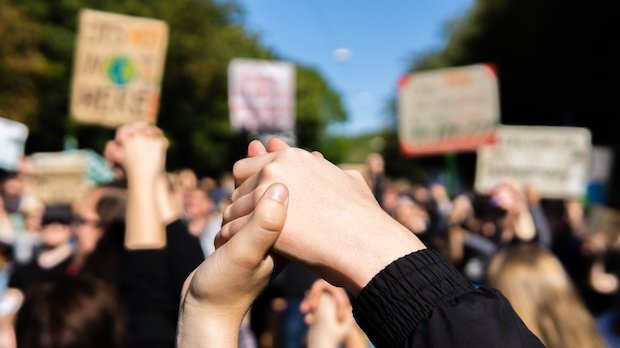 Zwei Junge Menschen reichen sich die Hände im Rahmen einer Fridays for Future Demonstration