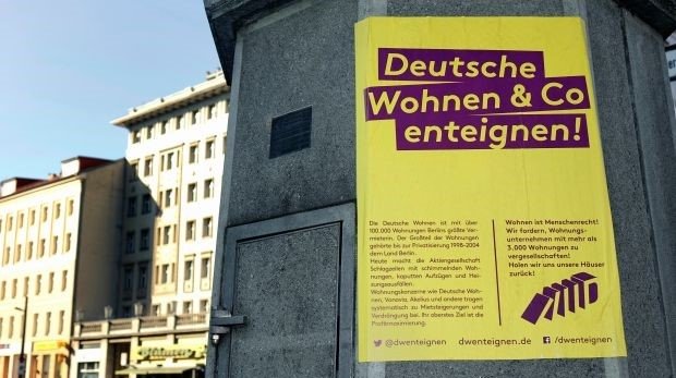 Ein Protestplakat gegen Deutsche Wohnen befindet sich an einem Strassenlaternensockel.