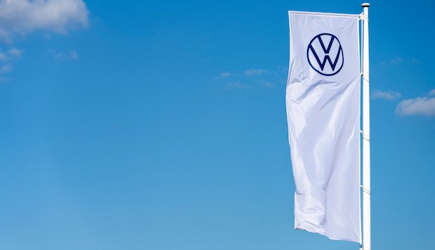 Eine Flagge mit VW-Logo vor blauem Himmel