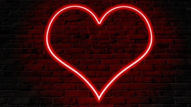 Rotes Neon-Herz auf Steinwand