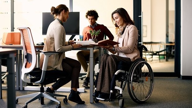 Eine Rollstuhlfahrerin im Büro