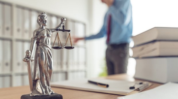 Eine Justitia-Figur auf dem Schreibtisch bei einem Anwalt