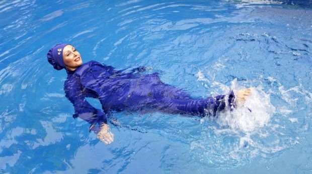 Frau schwimmt im Wasser mit einem Burkini (Symbolbild)