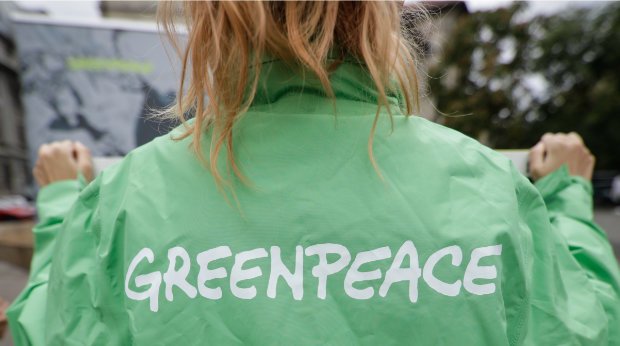 Eine Demonstrantin mit einer Greenpeace Jacke