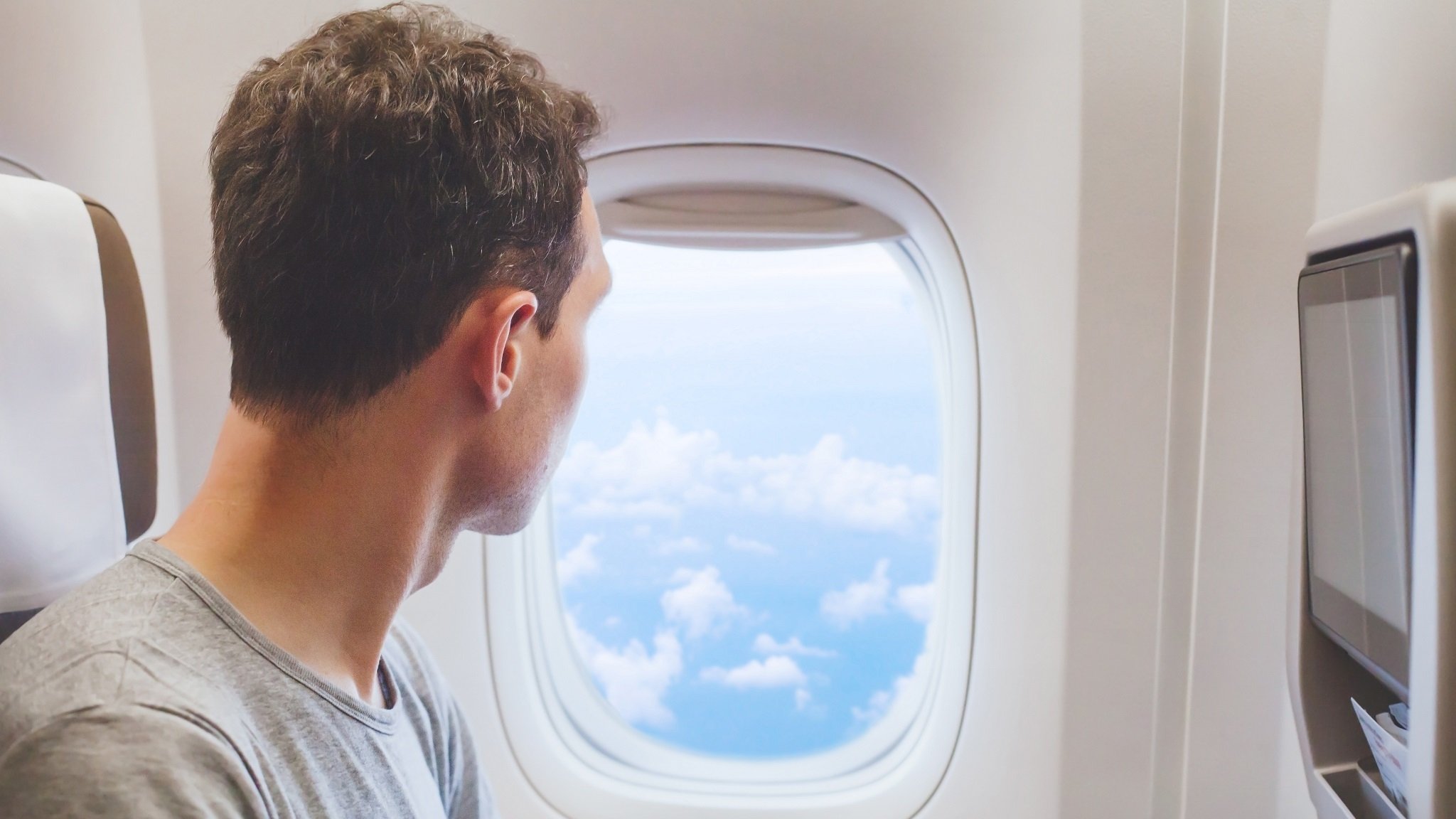 Kind blickt im Flugzeug aus dem Fenster