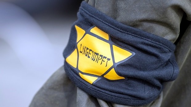 Bei einer Demonstration gegen die Einschränkungen durch die Pandemie-Maßnahmen der Bundesregierung am Brandenburger Tor trägt ein Teilnehmer eine Armbinde mit einem gelben Stern, der an einen Judenstern erinnern soll, mit der Aufschrift "Ungeimpft".