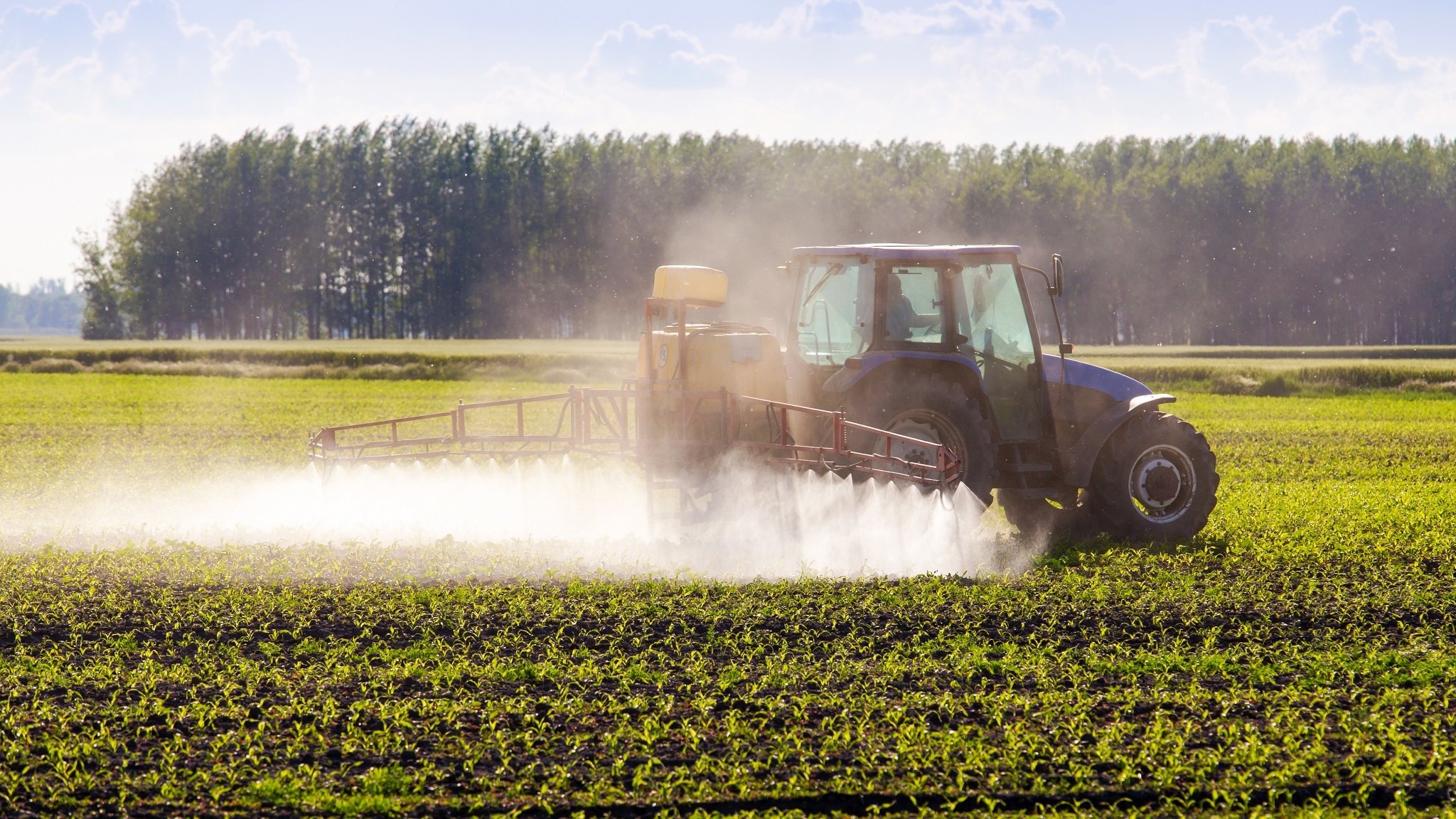 Ein Traktor bringt Pestizide aus.