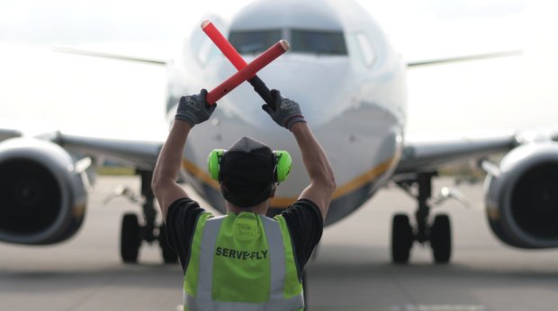 Ein Ryanair Flugzeug am Flughafen erhält Signale von einem Marshaller