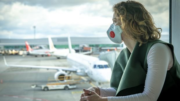Frau mit Maske am Flughafen