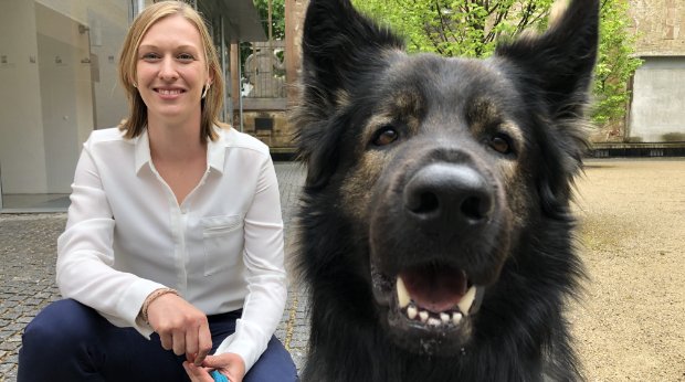 Sabine Kubinski, die Hundeführerin des Schäferhunds Al Capone, kniet im Hospitalhof neben dem zweijährige Hund, 25.4.2022.
