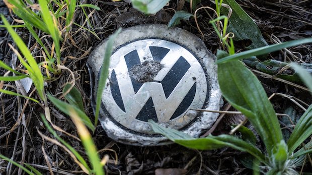 Logo VW schmutzig mit wachsendem Gras