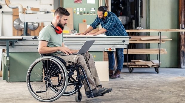 Ein Mann arbeitet im Rollstuhl (Symbolbild)